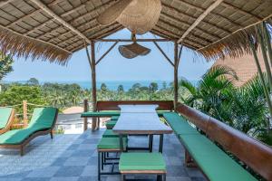un patio con tavoli, sedie e vista sull'oceano di Villa La Jade Chaweng Noi 2BR a Chaweng Noi Beach