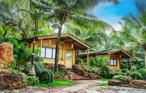 une maison avec des palmiers devant dans l'établissement ama Stays & Trails Eden Farms , Goa, à Marmagao
