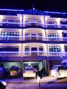 a large white building with cars parked in front of it at Apurna Guest House Dawki in Dawki