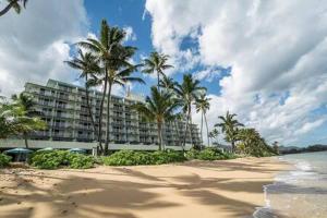 ein Hotel am Strand mit Palmen und dem Meer in der Unterkunft Beautiful Beachfront Condo in Laie