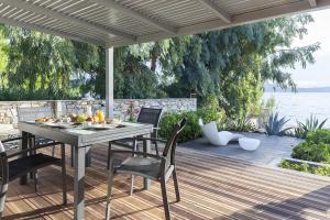 a table and chairs on a deck with a view of the water at ILYA SUITES BY THE SEA in Alonnisos