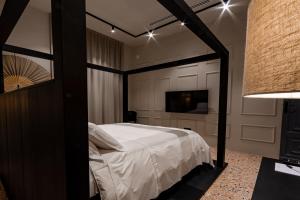Exclusive Room Pescara في بيسكارا: غرفة نوم بسرير مظلة وتلفزيون