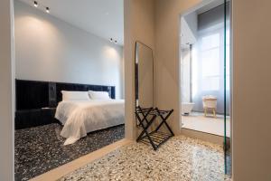 Exclusive Room Pescara في بيسكارا: غرفة نوم مع مرآة كبيرة وسرير
