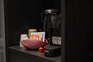 Exclusive Room Pescara في بيسكارا: رف مع آلة صنع القهوة وصحن من الطعام