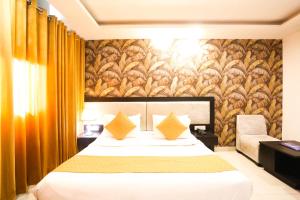 a hotel room with a bed with yellow pillows at Hotel Aashiyana New Delhi in New Delhi