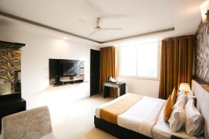 a hotel room with a bed and a television at Hotel Aashiyana New Delhi in New Delhi