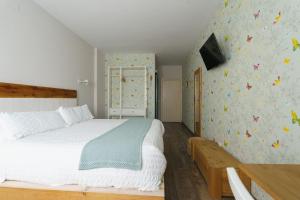 1 dormitorio con cama y pared con mariposas en Hotel Casa Cauma, en Albarracín