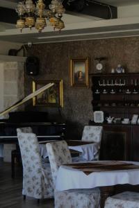 ein Esszimmer mit einem Klavier, einem Tisch und Stühlen in der Unterkunft Hotel Opera Jaz in Budva