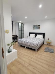 a bedroom with a bed and a wooden floor at Appartement COSY proche de Paris in Chambourcy