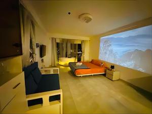 - une chambre avec un lit orange et une grande fenêtre dans l'établissement High Floor Seaview Beach Apartments-tub face to Ocean,projector,high speed Wi-Fi, à Jomtien Beach