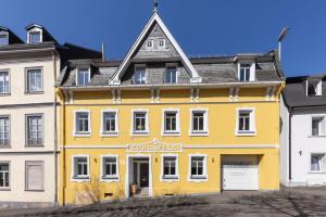 a yellow building in front of a white building at FerienNest Bad Ems, Appartment HeimatNest in Bad Ems