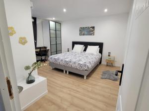1 dormitorio con 1 cama en una habitación blanca en Appartement COSY proche de Paris en Chambourcy