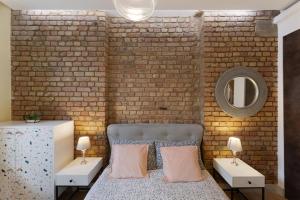 1 dormitorio con pared de ladrillo y cama con almohadas en Cozy Retreat Near Downtown with Parking, en Londres