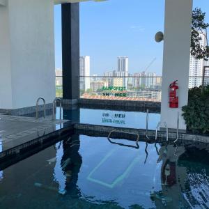 uma piscina de água em frente a um edifício em Urban Suite Penang Homestay 1B em Jelutong