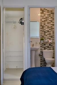 a bathroom with a toilet and a sink at Escape Studio Close to Agora Mall in Santo Domingo