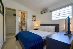 a bedroom with a bed and a television in it at Escape Studio Close to Agora Mall in Santo Domingo