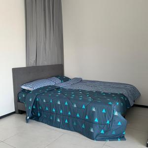 uma cama com um edredão azul num quarto em Urban Suite Penang Homestay 1B em Jelutong