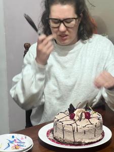 a woman holding a knife and a cake on a table at PROMAX villa in Nuwara Eliya