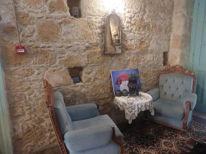un mur en pierre avec deux chaises et une table dans l'établissement Hotel Valide Hanim Konak, à Lefkosa Turk
