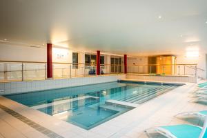 een groot zwembad in een gebouw bij Hôtel-Club Côté Dole, USSIM Vacances Les Rousses in Les Rousses
