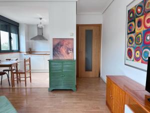 a living room with a green dresser and a table at Suite Rigel in Ponferrada