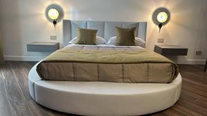 a large bed in a bedroom with two night stands at PALAZZO CHINIAL in Torre del Greco