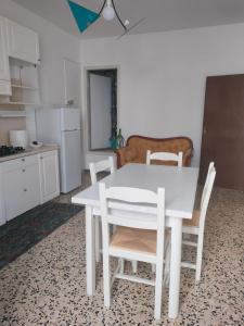 a kitchen with a white table and white chairs at Pisticci great View in Pisticci
