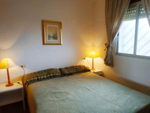 a bedroom with a bed with two lamps and a window at Peñiscola Playa Vista Mar Superior Orangecosta in Peñíscola
