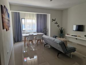 a living room with a table and chairs and a couch at Apartamentos Beira-Mar in Mindelo