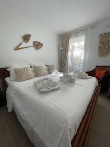 uma grande cama branca com toalhas em cima em GRIMAUD Vue piscine em Grimaud
