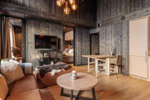 Kikut Alpin Lodge 2302 في جيلو: غرفة معيشة مع أريكة وطاولة