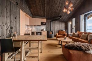 a kitchen and living room with a wooden ceiling at Kikut Alpin Lodge 2302 in Geilo