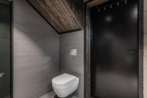 a bathroom with a toilet and a black door at SkiGeilo, Kikut Alpin Lodge in Geilo +9 photos