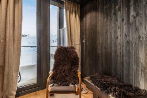 a dog sitting in a chair looking out the window at Kikut Alpin Lodge 2302 in Geilo