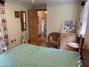 a bedroom with a bed and a dresser and a door at Llangollen cosy apartment in Llangollen