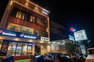 a building with cars parked in front of it at night at Treebo Trend Sans Sarav Kushalnagar in Madikeri