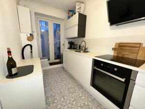 una cocina con fregadero y estufa horno superior en Seafront Medina, en Brighton & Hove