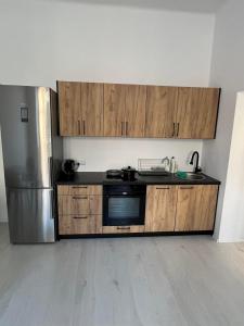 a kitchen with wooden cabinets and a stainless steel refrigerator at Apartament 2 pokoje, Przemyśl, 1 piętro in Przemyśl