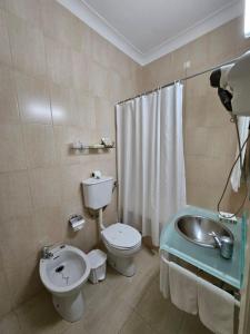 a bathroom with a toilet and a sink and a shower at Hotel Beira Mar in Angra do Heroísmo