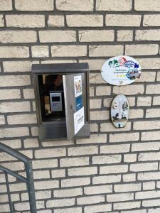 eine Backsteinwand mit Münztelefon drauf in der Unterkunft Appartment Haus Müller in Kelberg