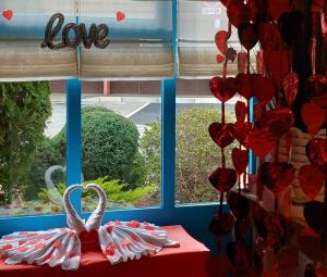 a window with red hearts and a white swan on a table at Kyriad Direct Marseille Ouest - Martigues in Martigues