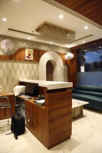 eine Küche mit einer Theke, einem Schreibtisch und einem Sofa in der Unterkunft Hotel JR Grand 100 Meter From Golden Temple in Amritsar