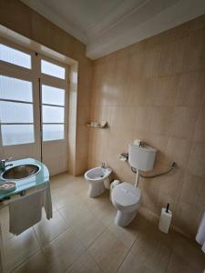 a bathroom with a toilet and a sink at Hotel Beira Mar in Angra do Heroísmo