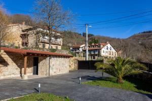 une maison en pierre avec un garage dans une allée dans l'établissement Sandoñana Old Palace Lodge, à Villafufre