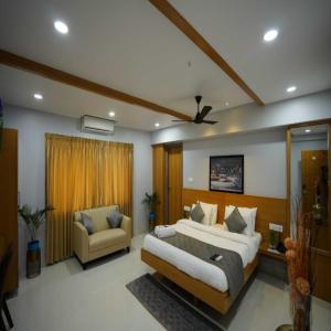a bedroom with a large bed and a chair at Happy Nest Guest Home in Kurmannapalem