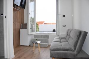 a living room with a couch and a window at Apartman Lucana in Tribunj