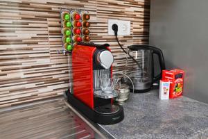 a red blender sitting on top of a counter at Vár-Lak Apartman in Sümeg +30 photos