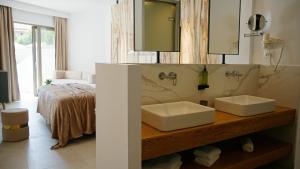 Diana Palace Hotel Zakynthos في أرغاسي: حمام مغسلتين بيض وسرير