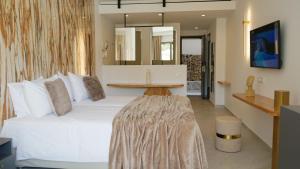 a bedroom with a large white bed with a table at Diana Palace Hotel Zakynthos in Argassi +100 photos