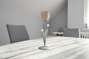 um vaso com uma flor em cima de uma mesa em Vár-Lak Apartman em Sümeg